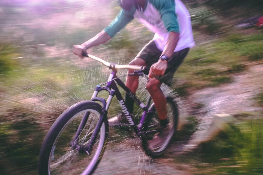 Man Riding Black and White Hardtail Mountain Bike