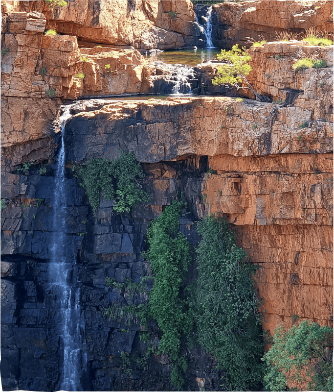 Flowing waterfall cascading down red rock cliffs in a stunning natural landscape.